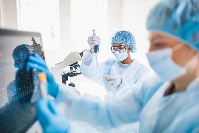 researchers taking a samples from a test tube