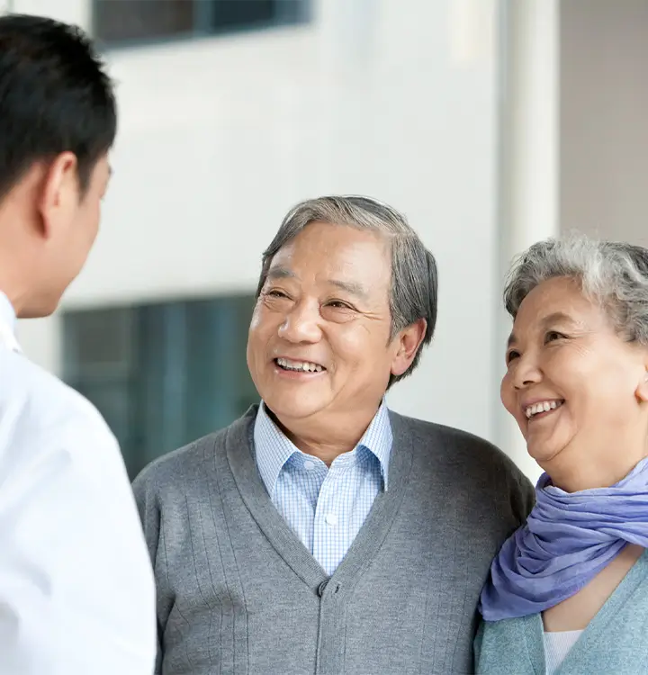 Happy elderly couple speaking to clinican